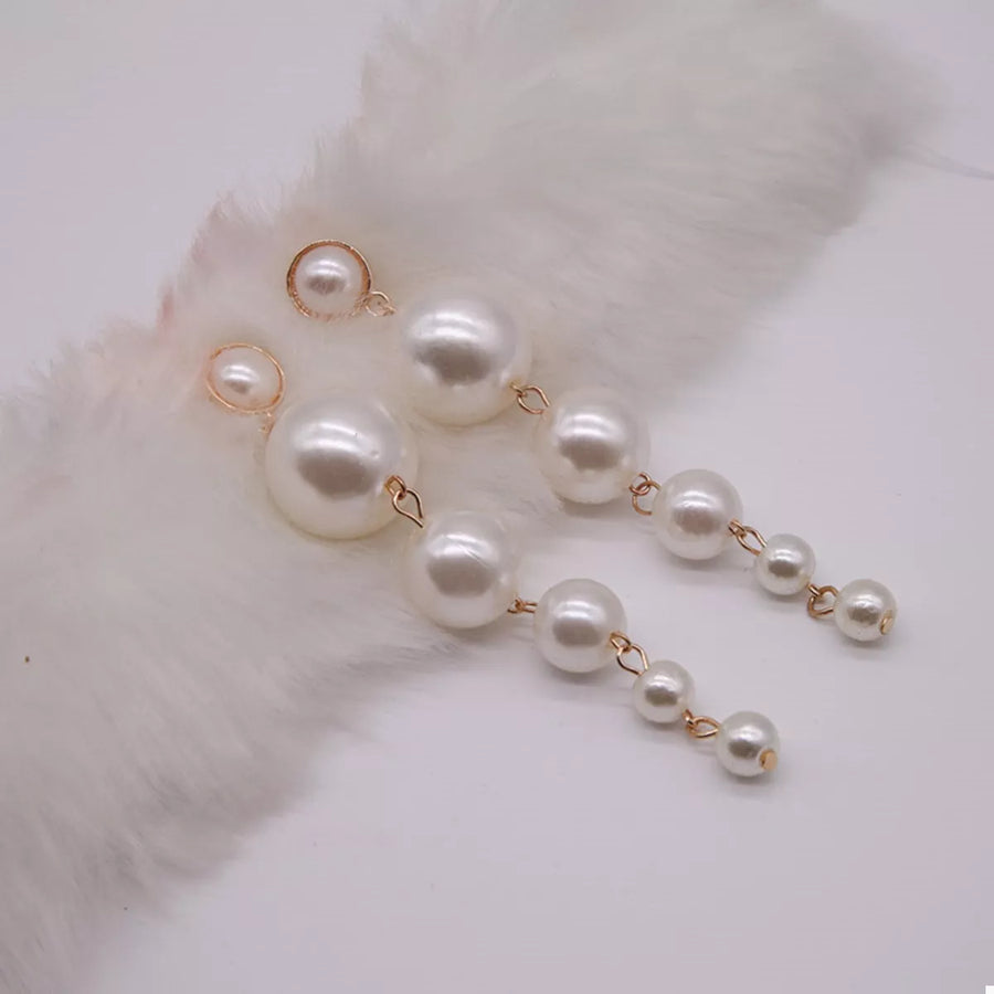 Gold cascading pearl drop earrings with varying pearl sizes.
