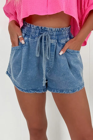 Paperbag waist denim shorts in medium wash with drawstring and relaxed fit.