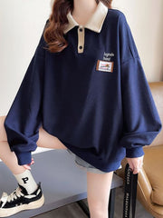 Navy waffle-knit polo sweatshirt with a contrast collar and button placket, featuring a graphic patch.
