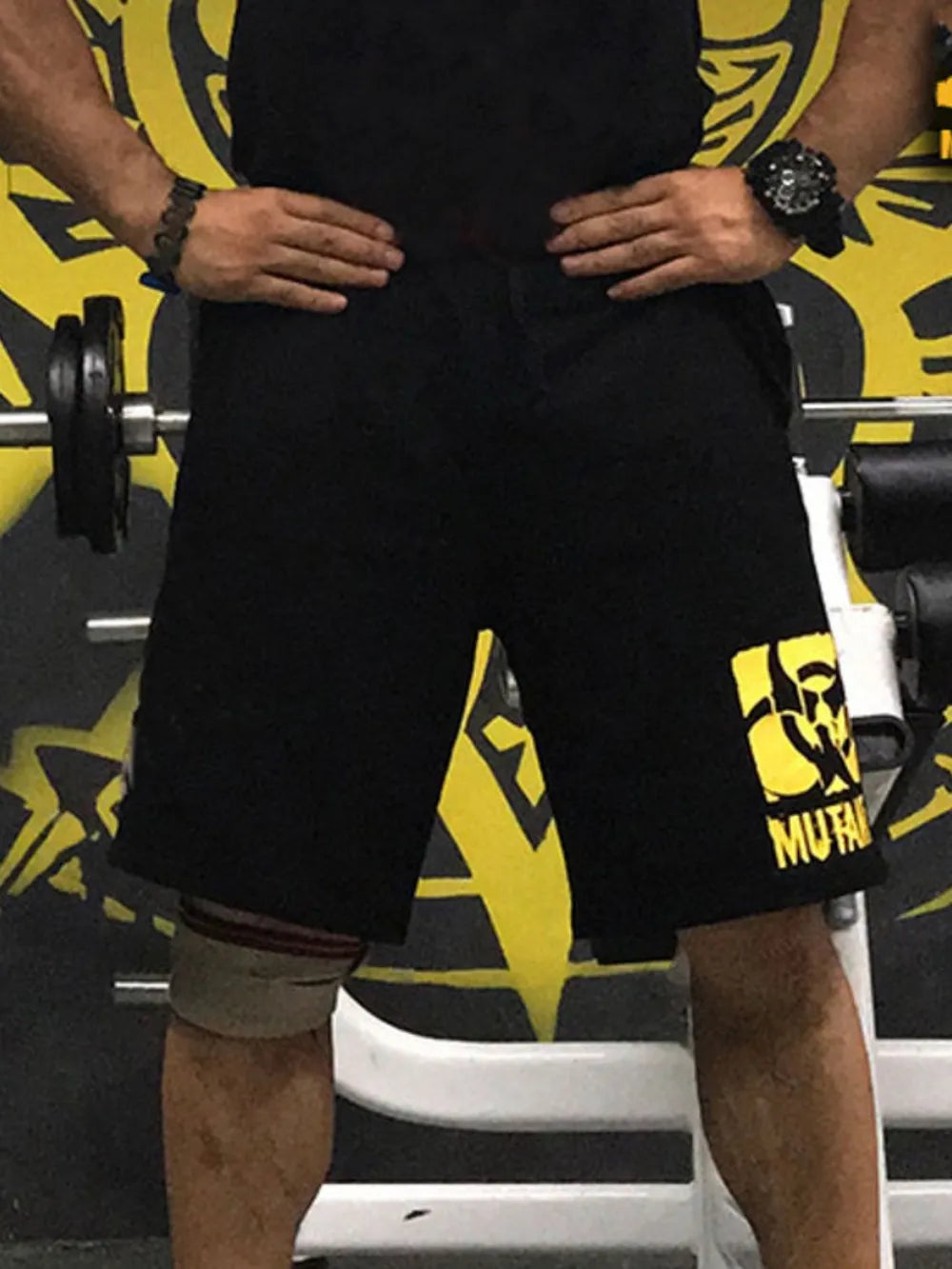 Black gym shorts with yellow Mutant logo detail on the left leg.