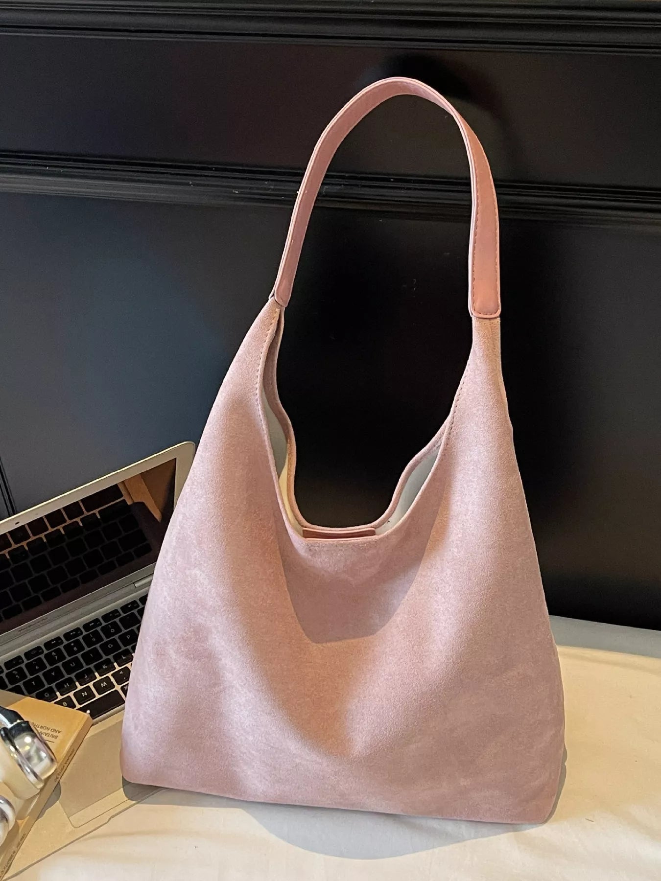 Dusty pink suede shoulder bag with a single strap.