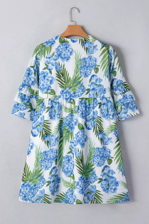 Ruffled mini dress with hydrangea and palm print, featuring a smocked waist and flutter sleeves.