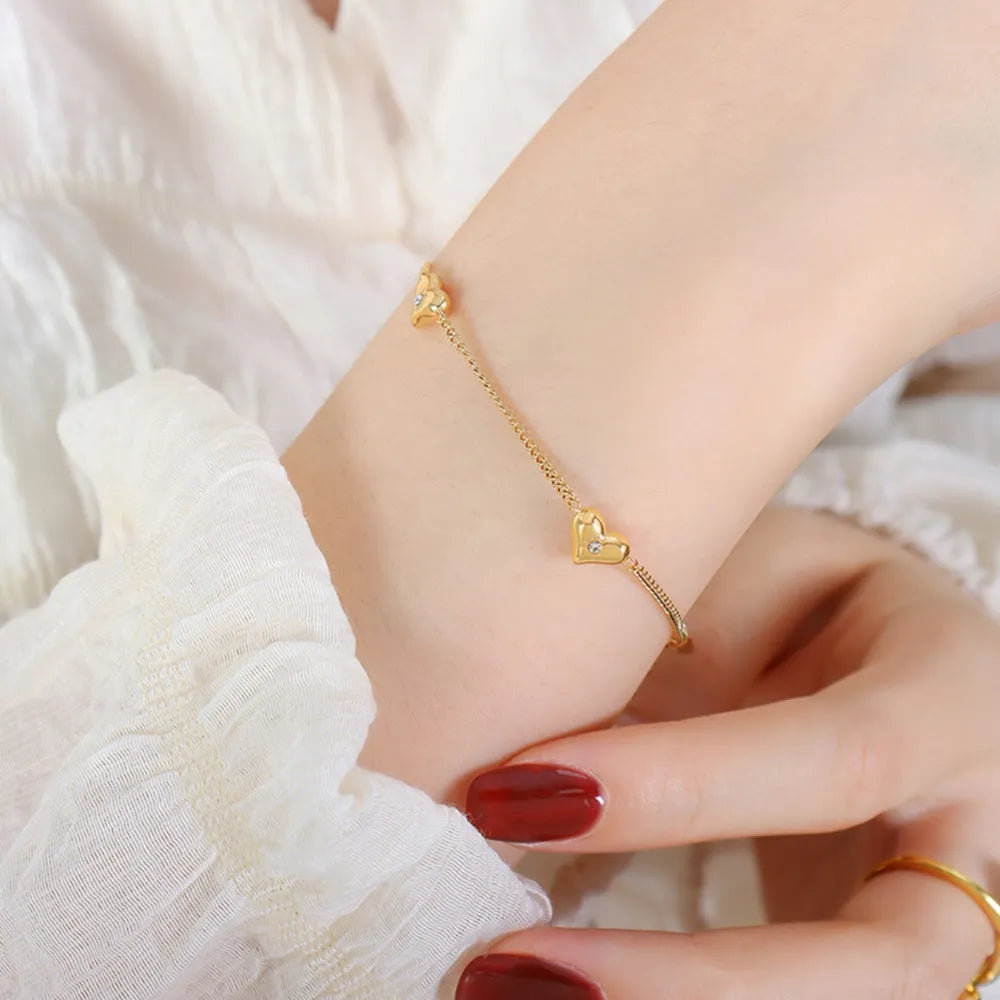 Gold chain bracelet with heart charms and diamonds