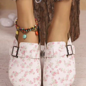 Floral print slip-on flats in beige with decorative buckle detail and colorful anklet.