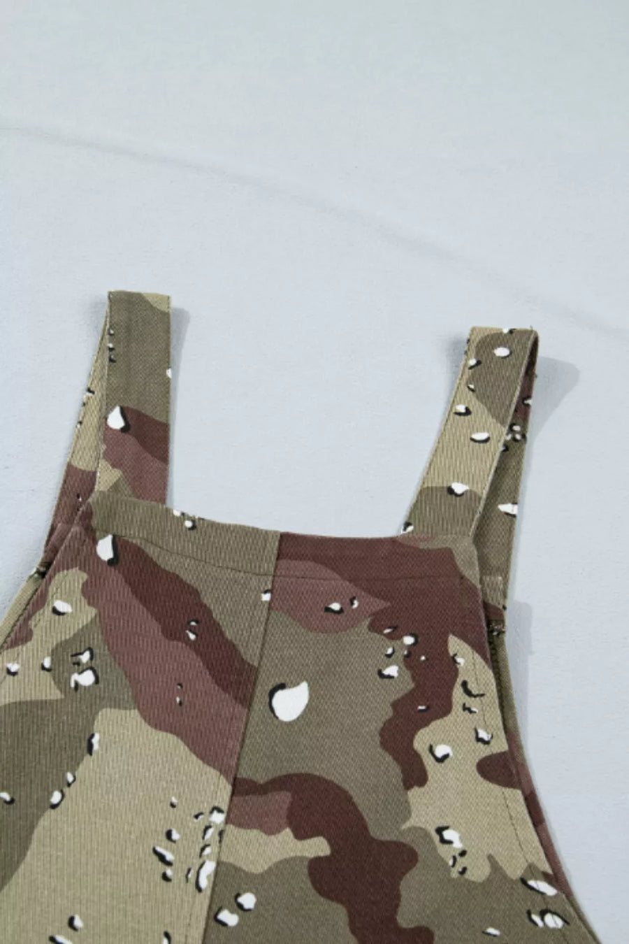 Denim cropped overall with camouflage pattern and white speckles.