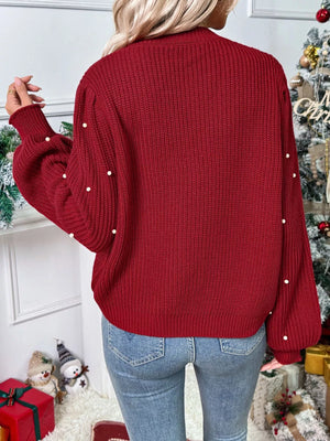 Red acrylic knit cardigan with pearl embellishments on sleeves and back.