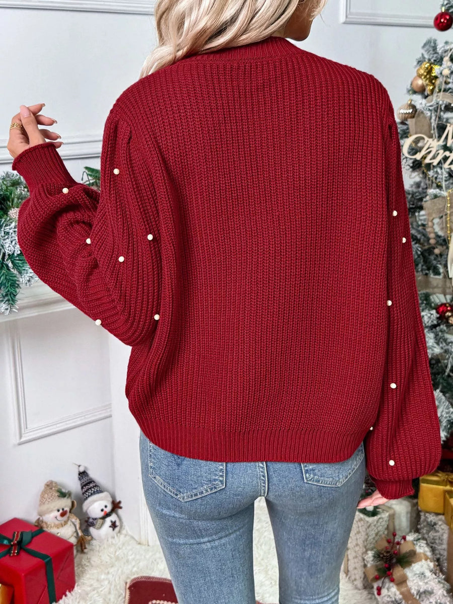 Red acrylic knit cardigan with pearl embellishments on sleeves and back.