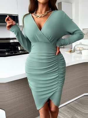 Greyish green ruched surplice bodycon dress with long sleeves and V-neck.