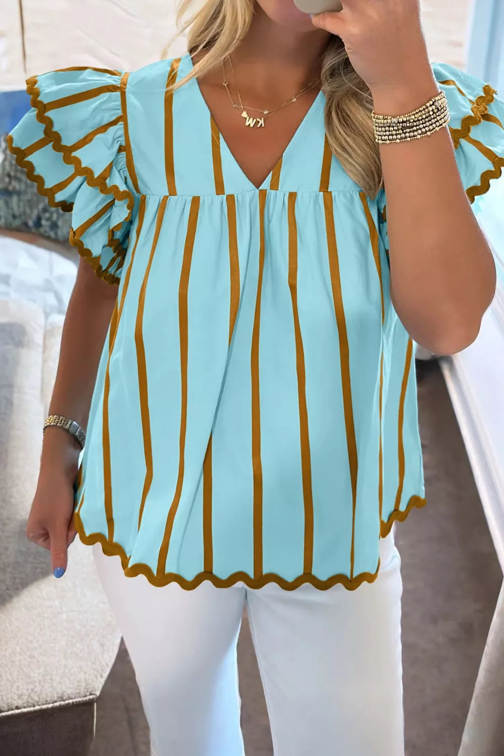 Light blue cotton blend blouse with brown stripes, V-neck, ruffled sleeves, and scalloped hem.