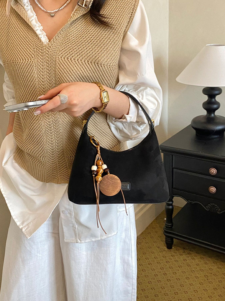 handbag in Black with decorative charm and small