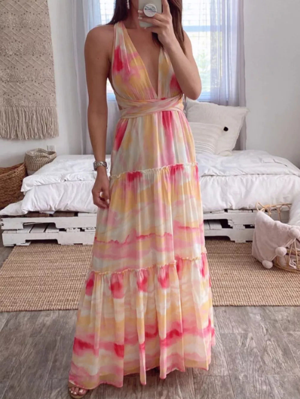 Vibrant tie-dye maxi dress with halter neckline, tiered skirt, and wrap waist.