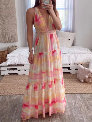 Vibrant tie-dye maxi dress with halter neckline, tiered skirt, and wrap waist.