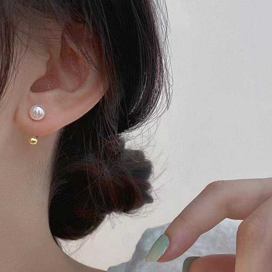 Sterling pearl stud earrings with gold ball back detail.