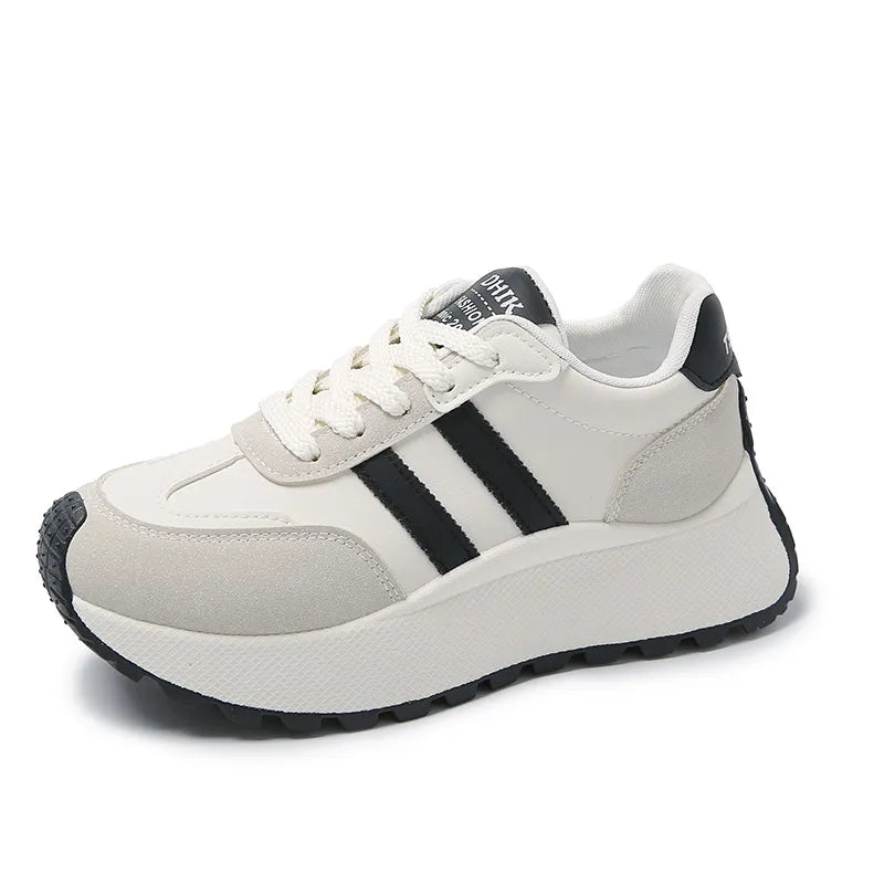 White platform trainers with black stripes and suede accents.
