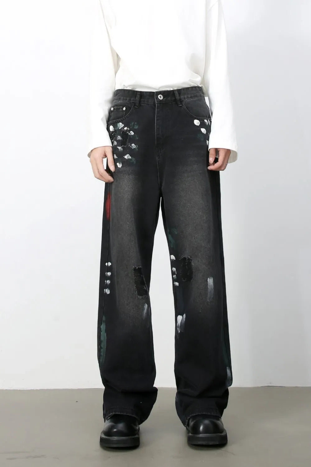 Dark wide-leg jeans with painterly distressed details and artistic brushstrokes.