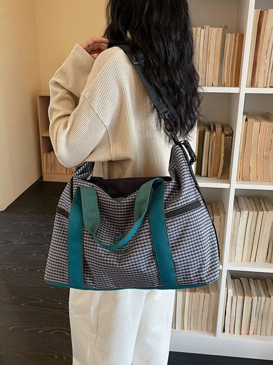 Large plaid travel bag with teal straps and versatile shoulder strap.