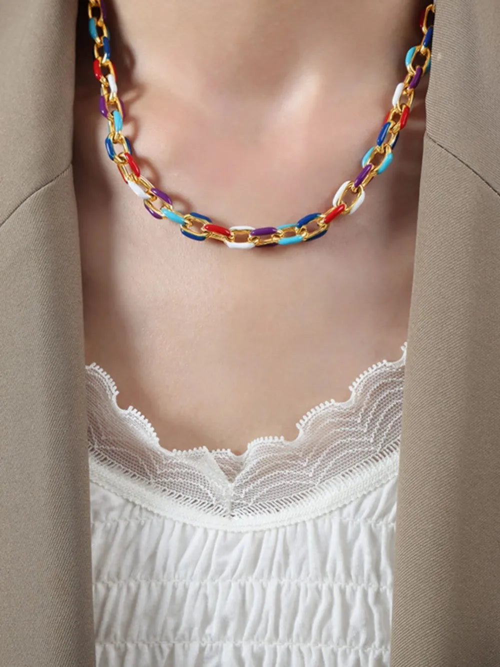 Gold chain necklace with colorful enamel links and a white lace trim top.