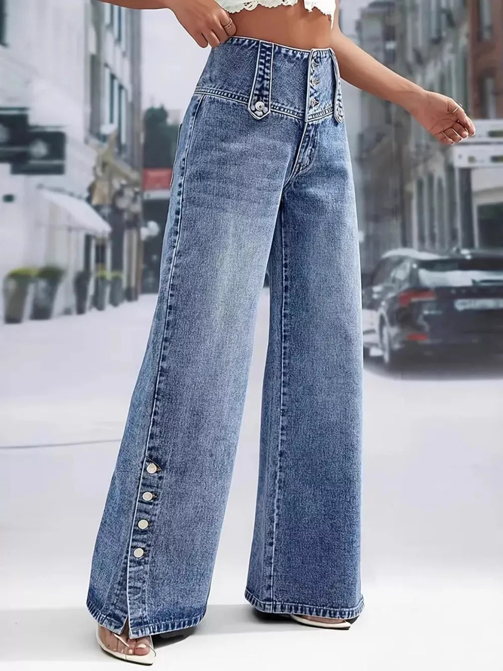 Wide-leg denim jeans with button accents and a high waist.
