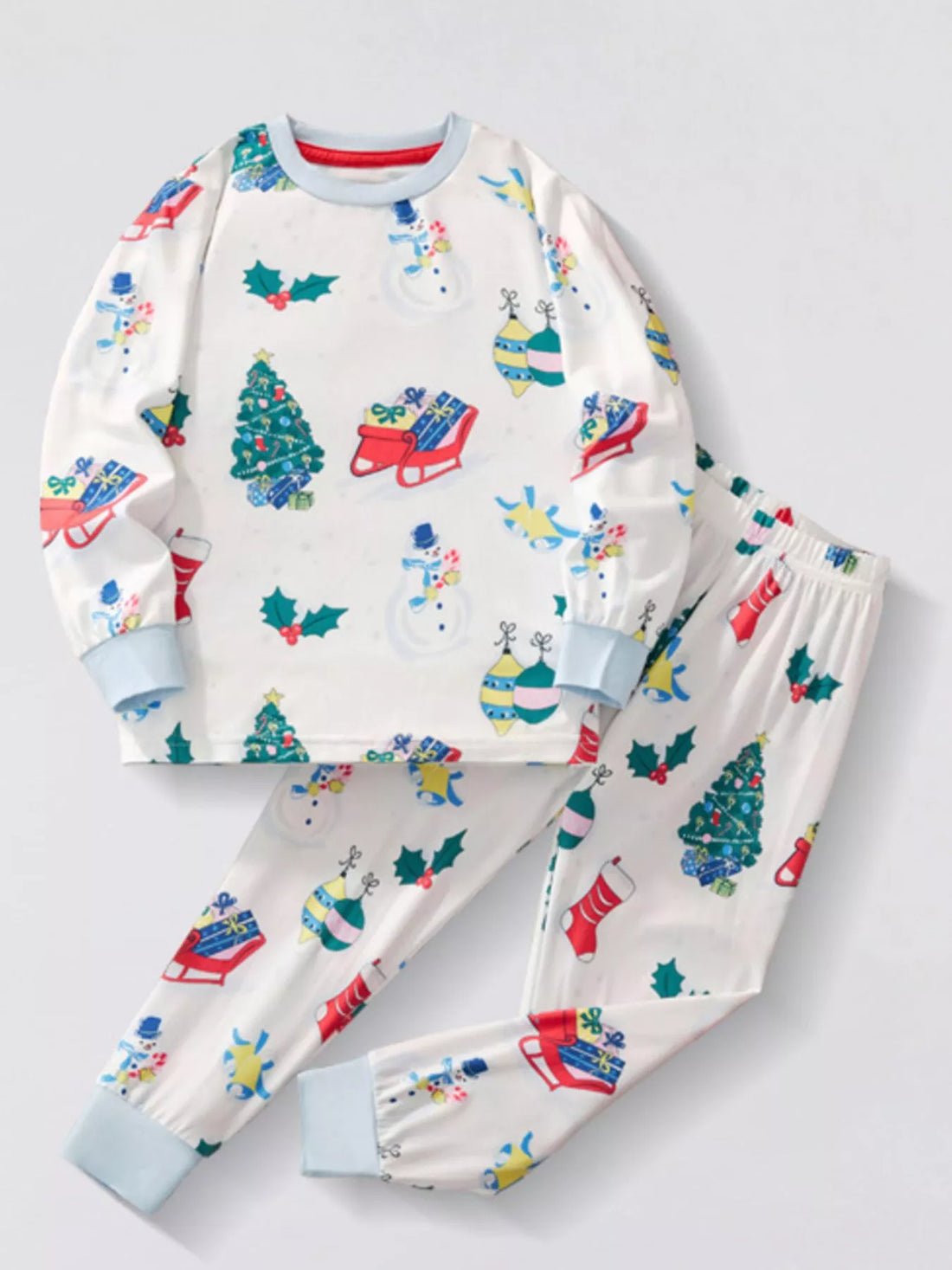 White children's long sleeve pajama set with festive Christmas print of snowmen, trees, and gifts.