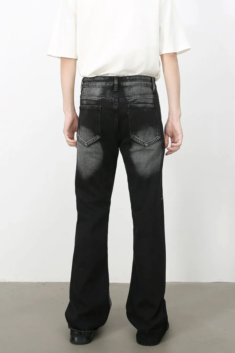 Distressed flare jeans in dark shadow wash denim with a bootcut leg.