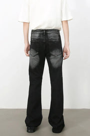 Distressed flare jeans in dark shadow wash denim with a bootcut leg.