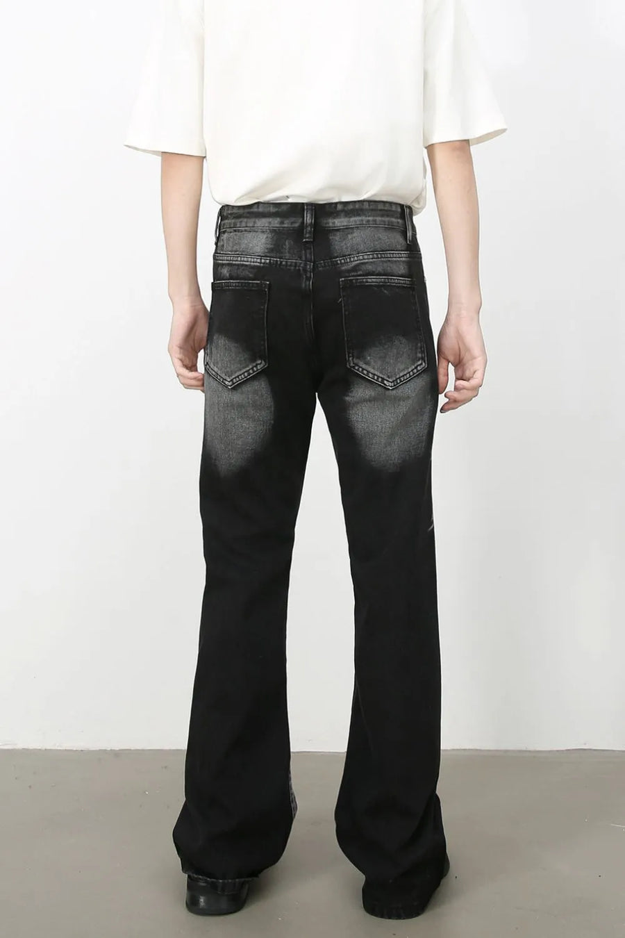 Distressed flare jeans in dark shadow wash denim with a bootcut leg.