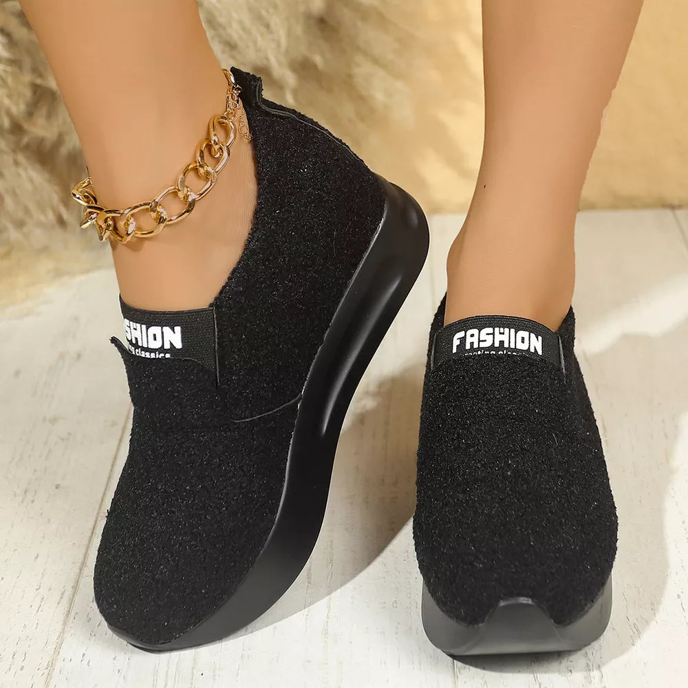 Black textured round toe platform sneakers with "FASHION" elastic band and gold chain anklet.