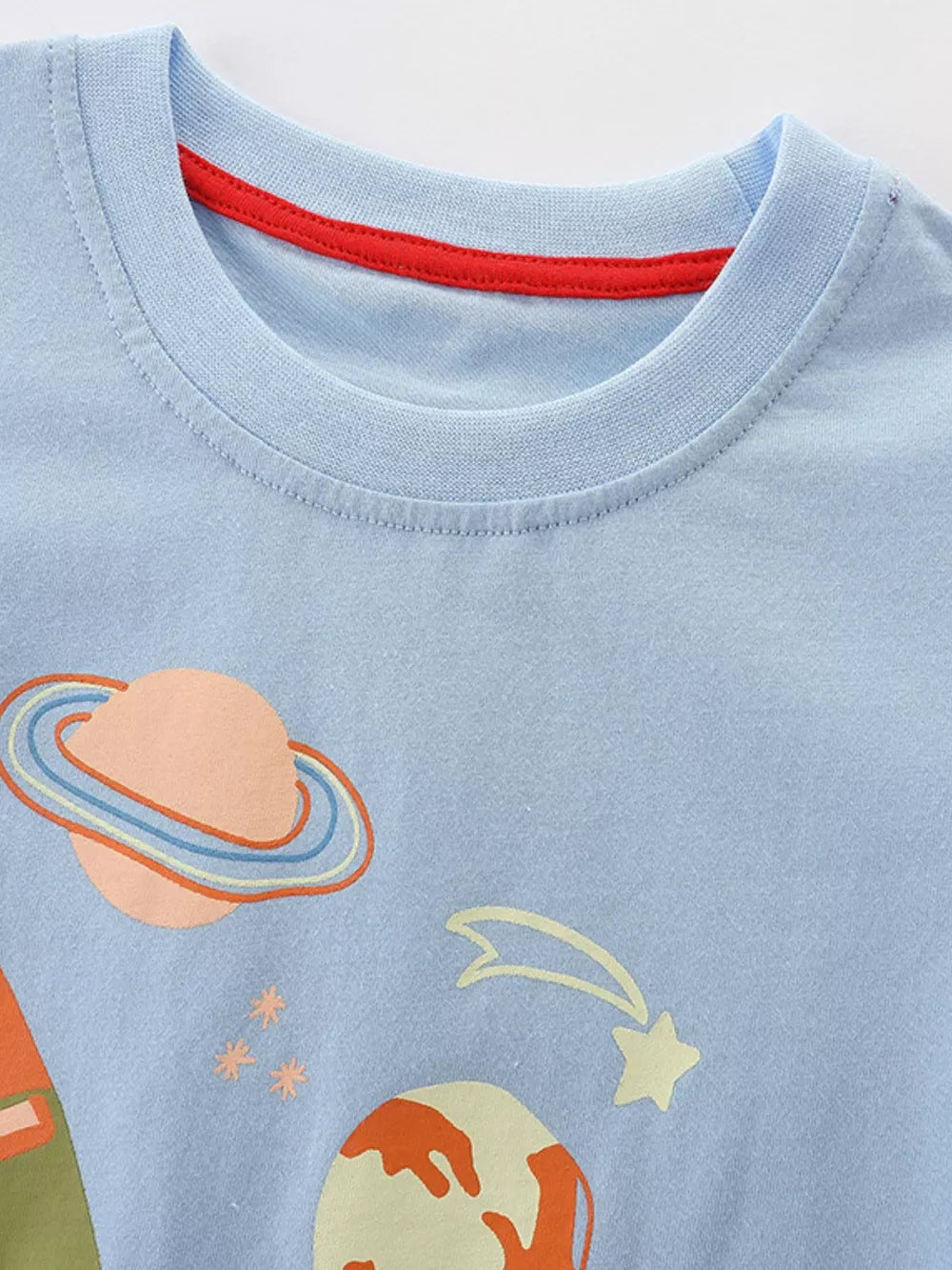 Light blue cotton crew neck t-shirt with space adventure graphic and red neck trim.