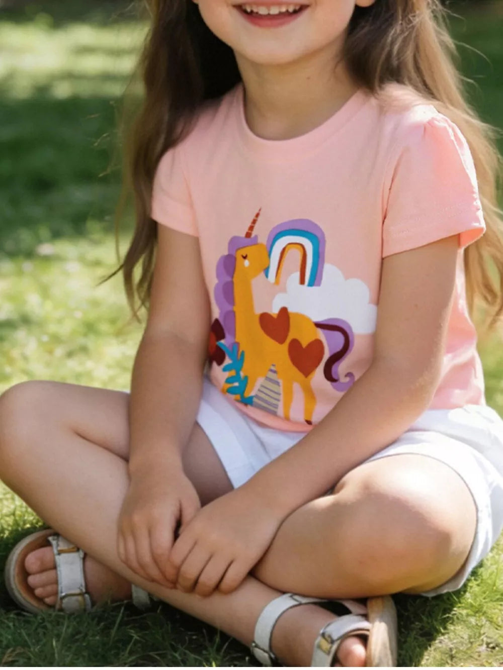 Children's blush pink cotton t-shirt with a yellow unicorn and rainbow graphic.