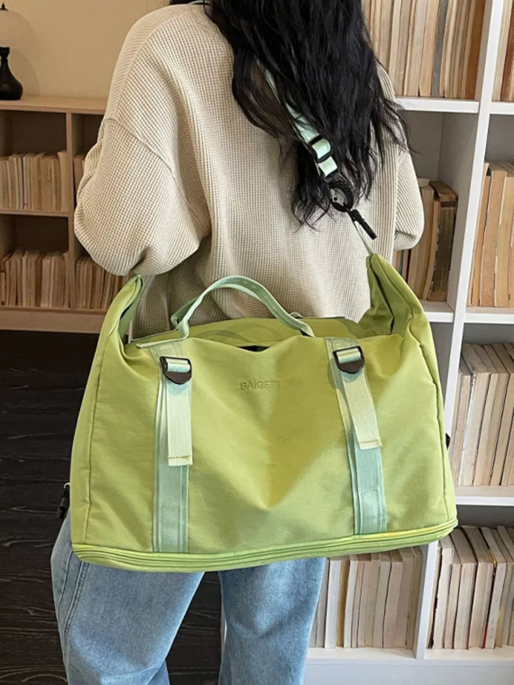 Green nylon travel bag with buckle straps and adjustable shoulder strap.