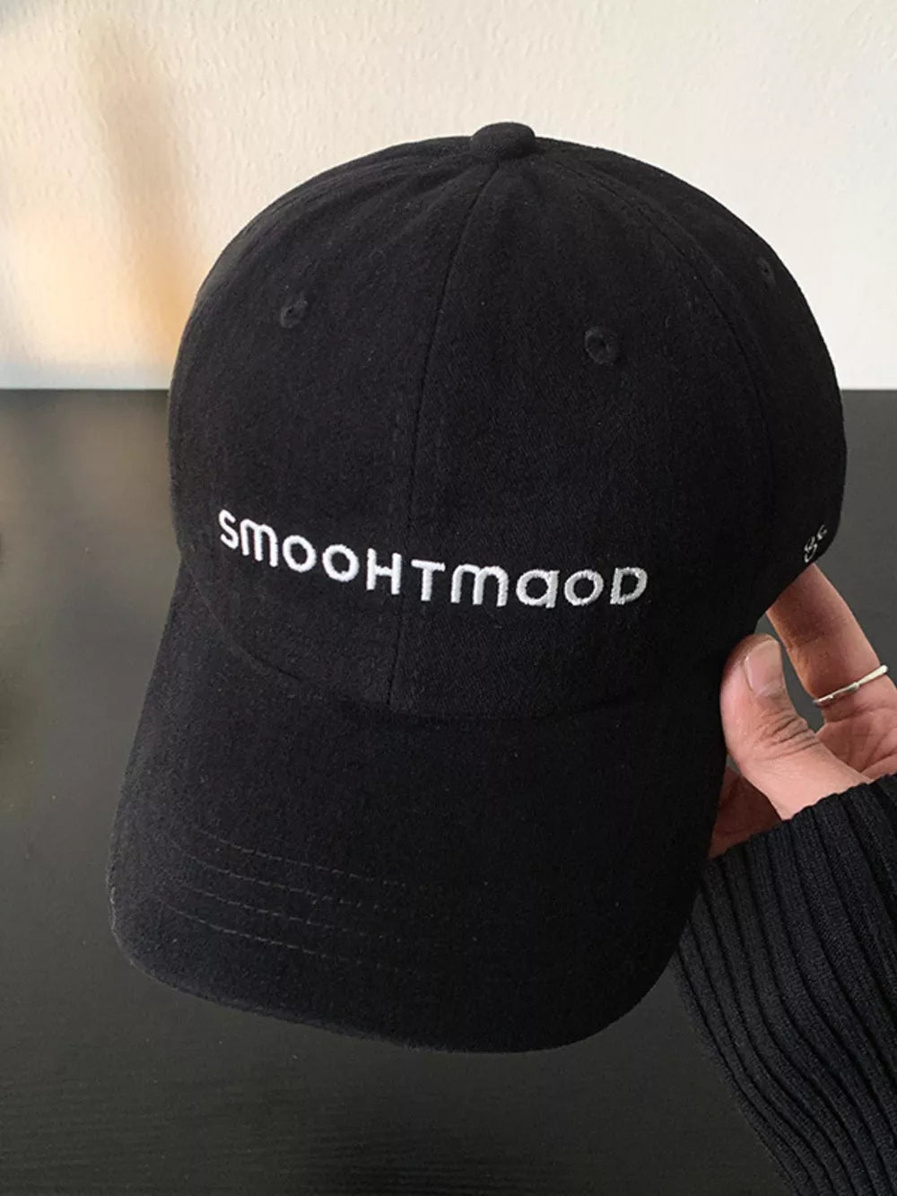 Black cotton baseball hat with white embroidered text and curved brim