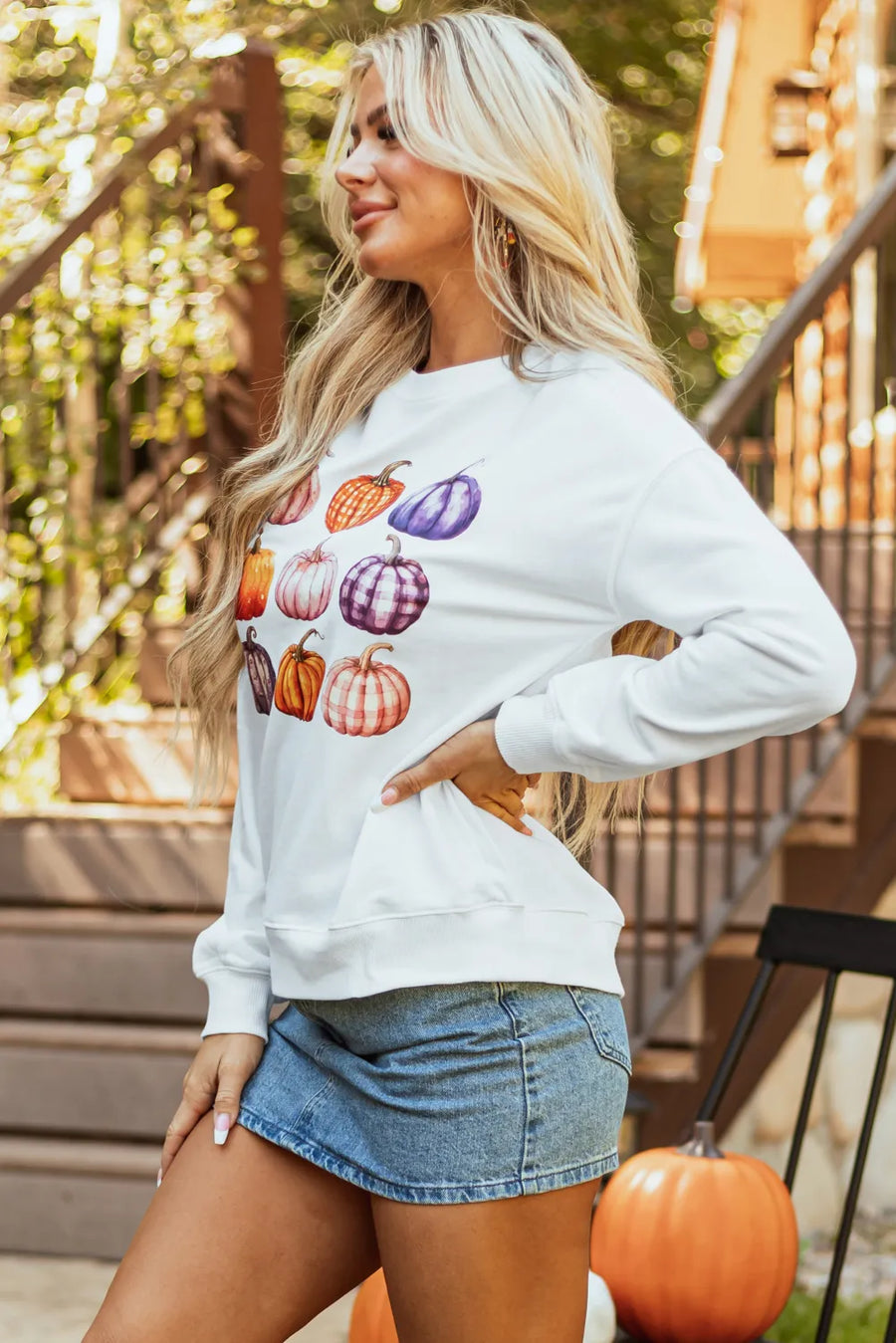 White crewneck sweatshirt with watercolor pumpkin patch print, casual autumn style.