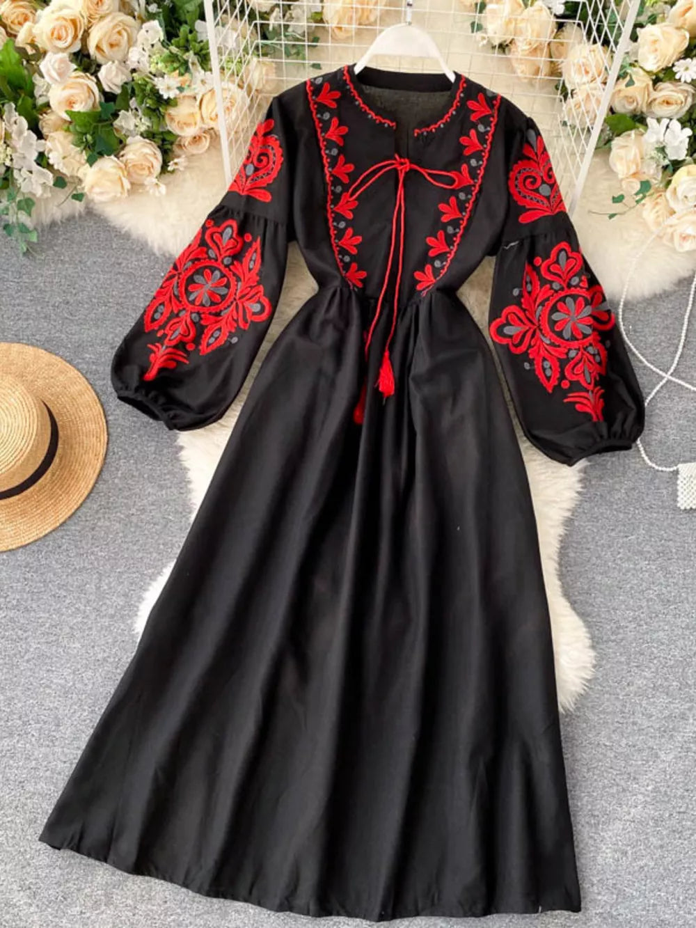 Black maxi dress with red floral embroidery and balloon sleeves.