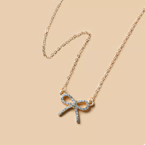 Gold bowknot pendant necklace with clear crystals on a delicate chain