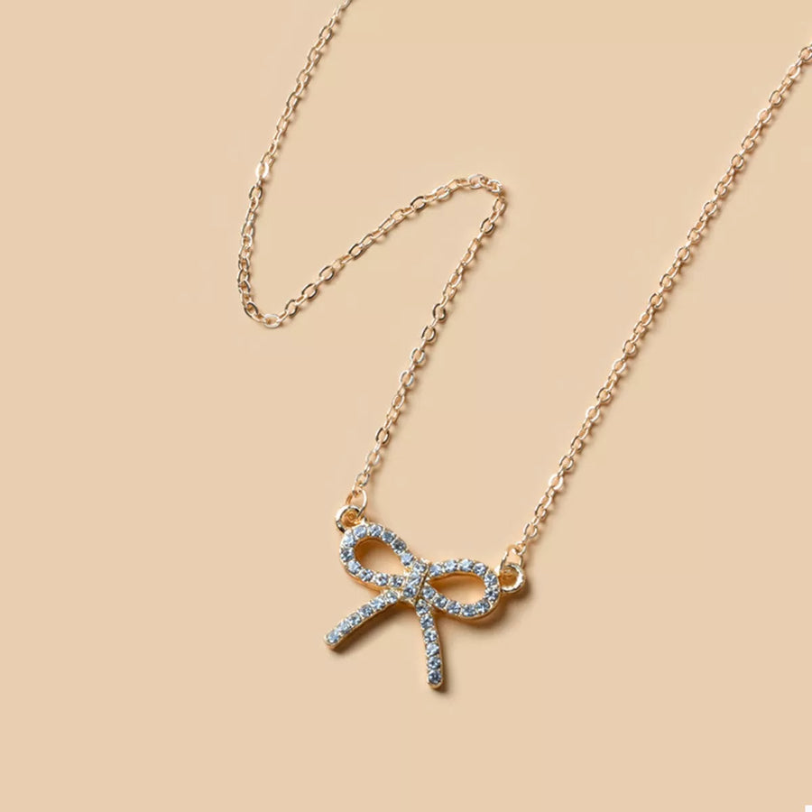 Gold bowknot pendant necklace with clear crystals on a delicate chain
