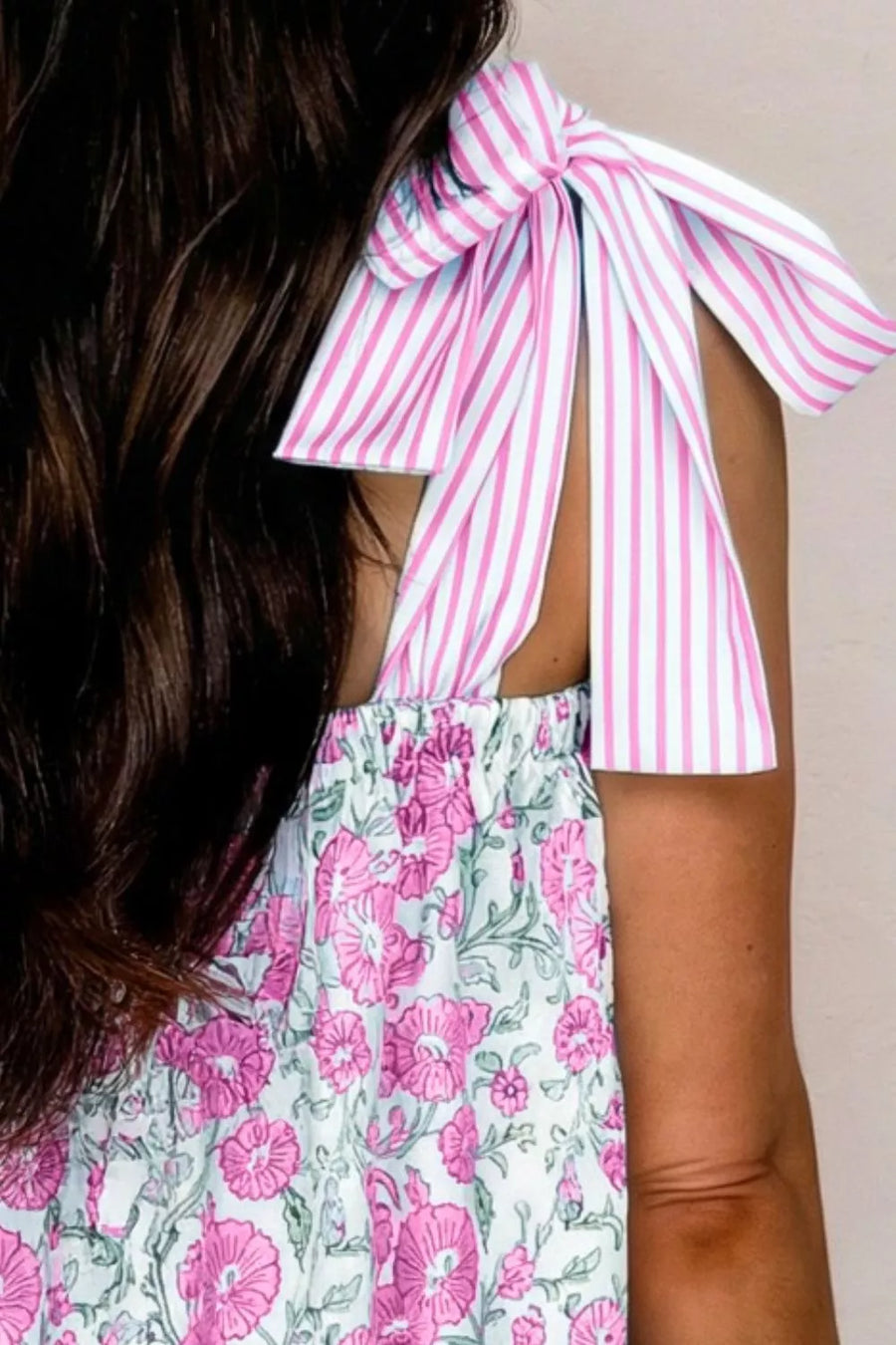 Floral mini dress with pink and white striped tie shoulders and a pink floral print skirt.