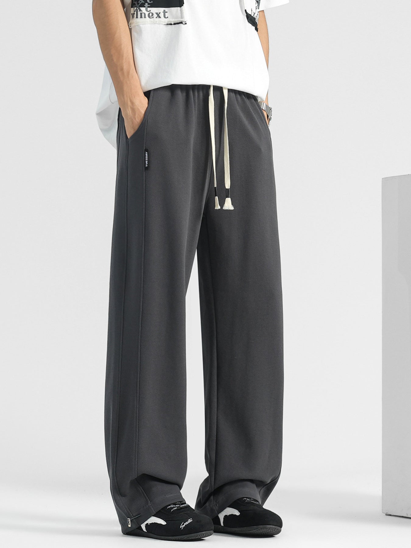 Men's dark gray loose-fit drawstring sweatpants with pockets and side seams.