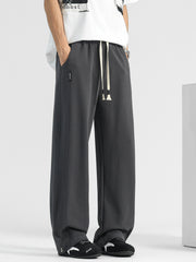 Men's dark gray loose-fit drawstring sweatpants with pockets and side seams.