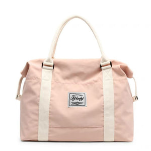 Premium large capacity travel duffel bag in dusty pink with white straps and a central logo patch.