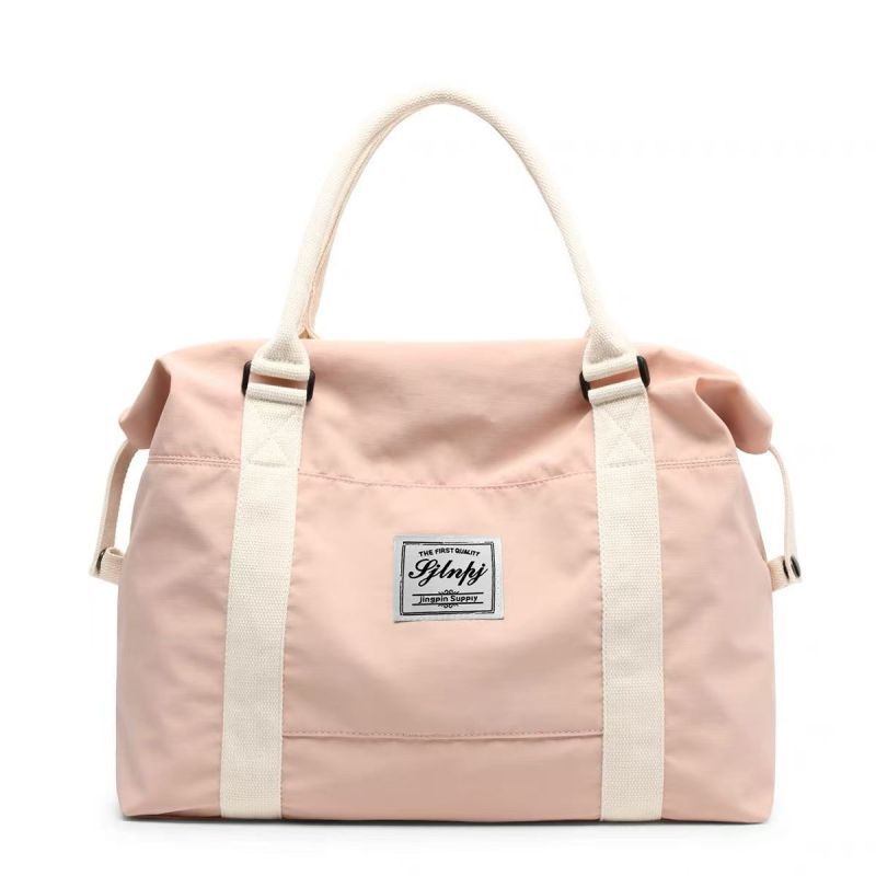 Premium large capacity travel duffel bag in dusty pink with white straps and a central logo patch.
