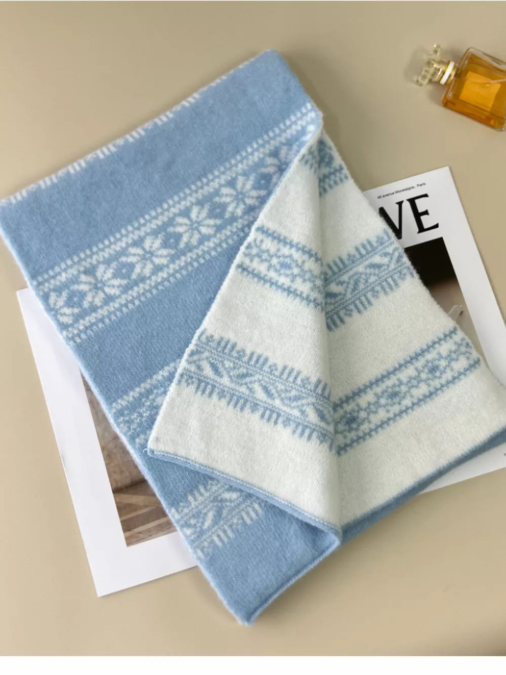 Reversible wool blend scarf in sky blue with white snowflake pattern.
