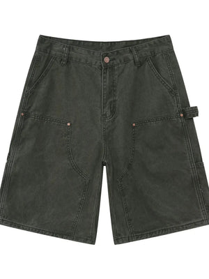 Utility denim carpenter shorts in washed olive with large front pockets and a hammer loop detail.