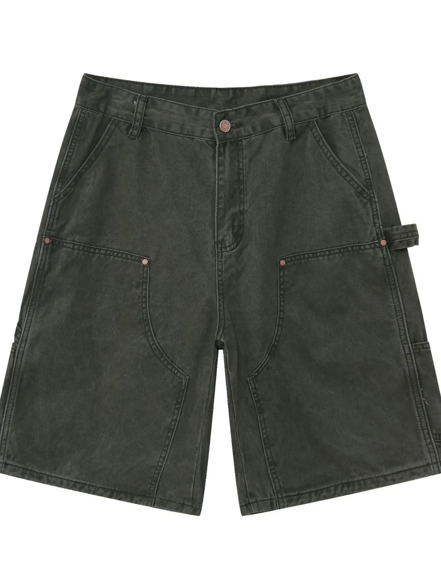 Utility denim carpenter shorts in washed olive with large front pockets and a hammer loop detail.