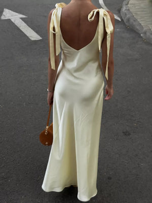 Cream satin slip dress with tie shoulder straps and a deep V-neck.