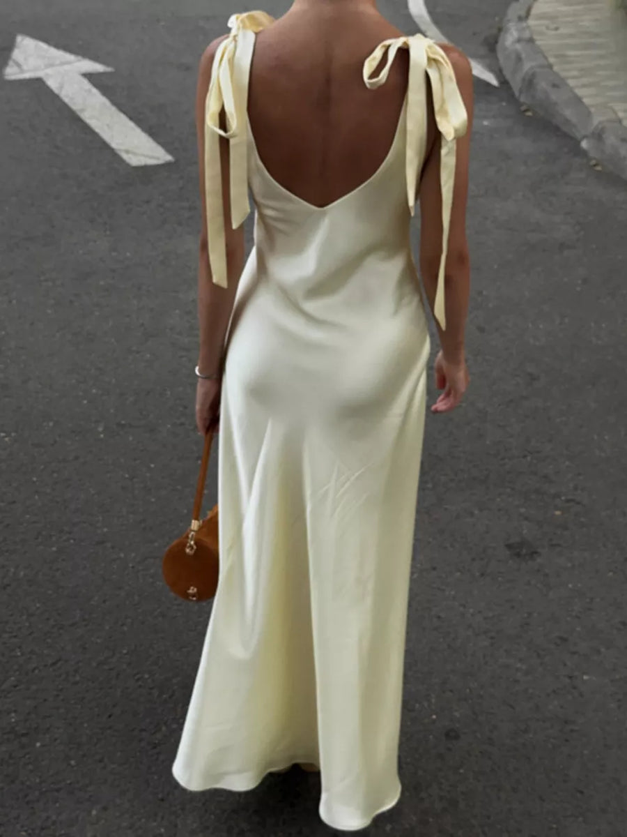 Cream satin slip dress with tie shoulder straps and a deep V-neck.