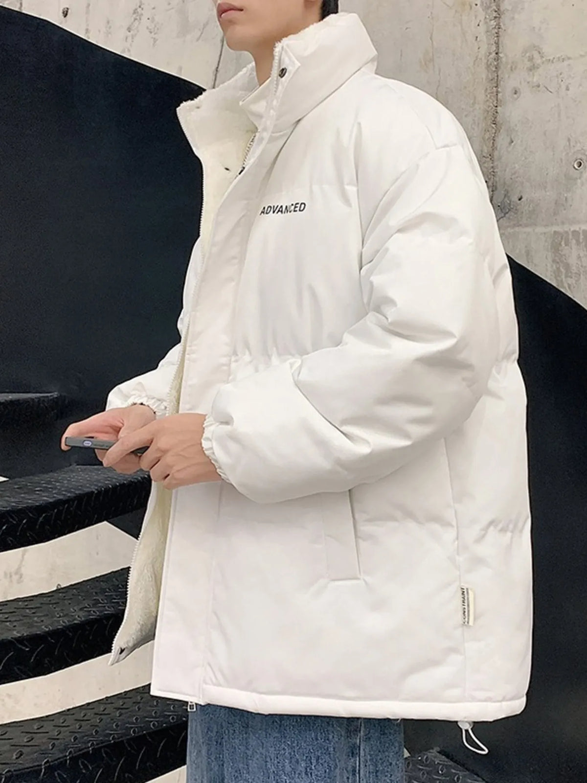 White oversized quilted puffer jacket with a high neck and "ADVANCED" text detail.