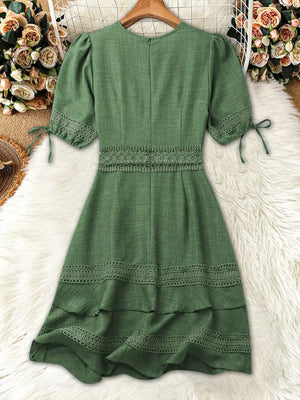 Green lace-embellished V-neck mini dress with puff sleeves and tiered hem.