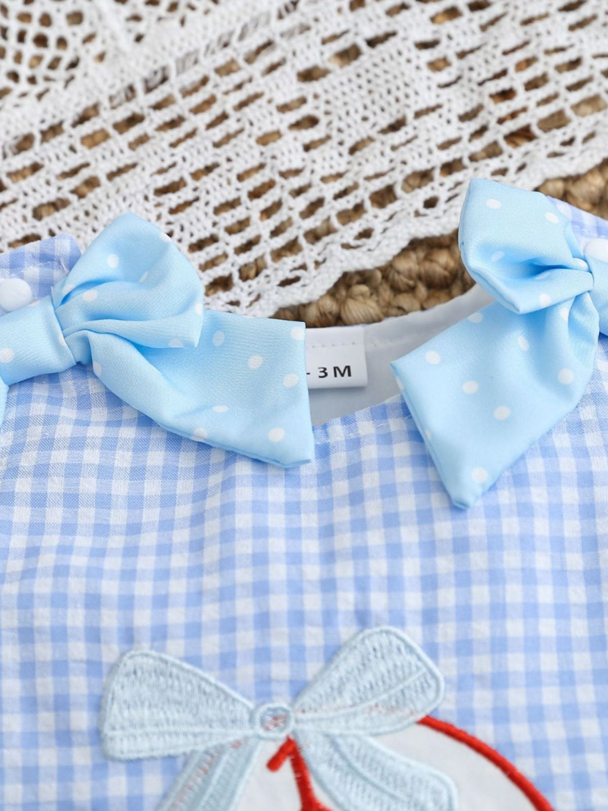 Baby blue gingham one-piece with white polka dot bows and baseball embroidery.
