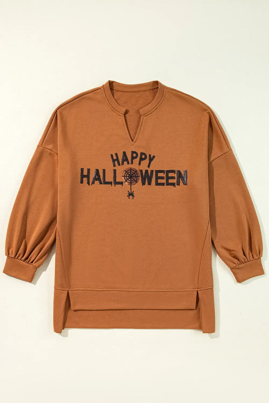 Caramel Halloween graphic slit hem sweatshirt with V-neck and balloon sleeves.