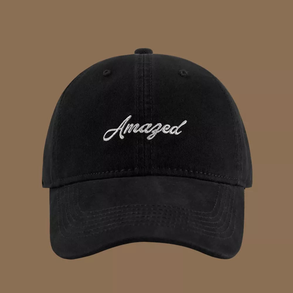 Black cotton baseball cap with white embroidered "Amazed" text